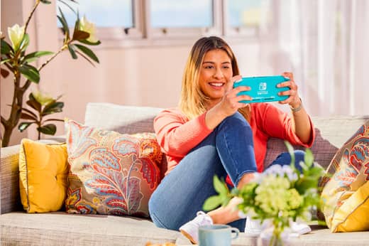 A woman is enjoying a game of Big Brain Academy: Brain vs. Brain on her Nintendo Switch Lite system.