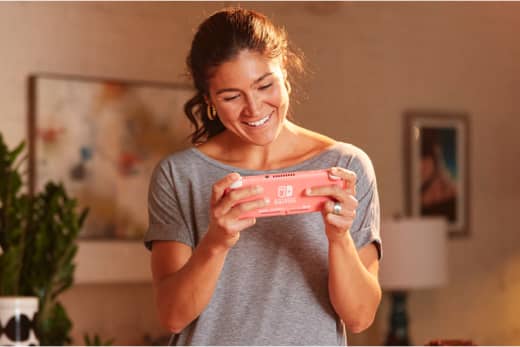 A woman is playing the game on a Nintendo Switch Lite system.
